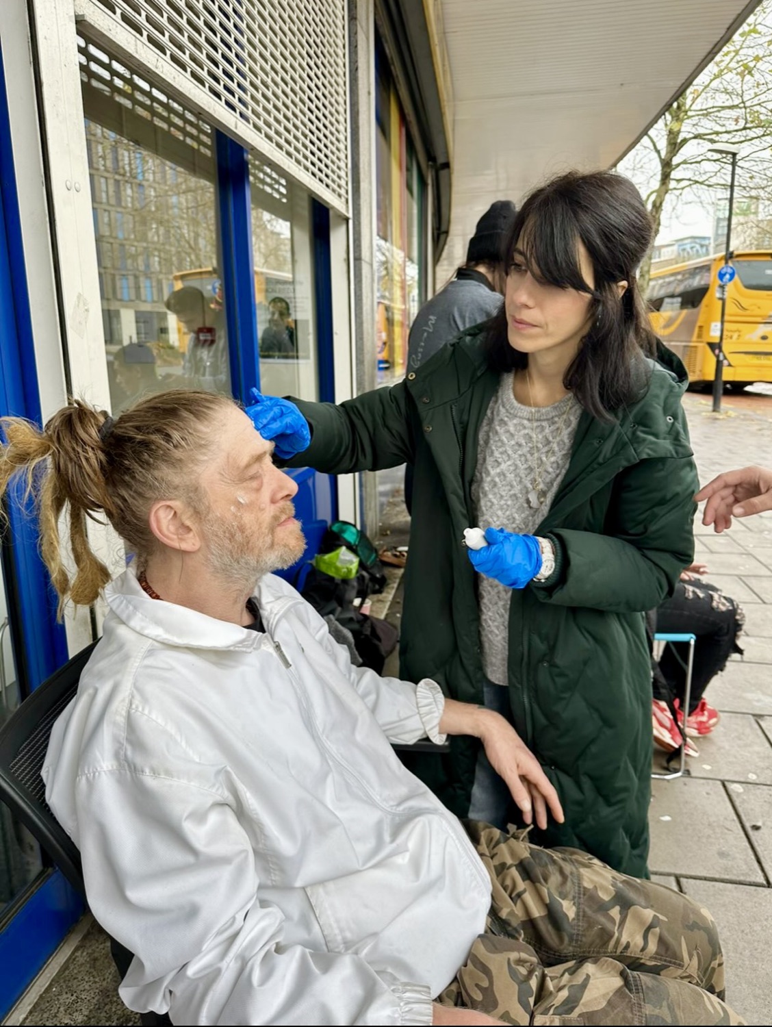 Natacha caring for a man sitting outside on the street